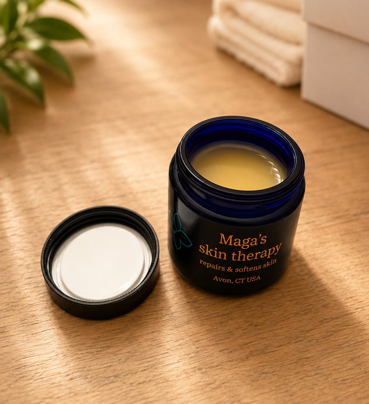 Open jar of Maga's Skin Therapy balm on a wooden table